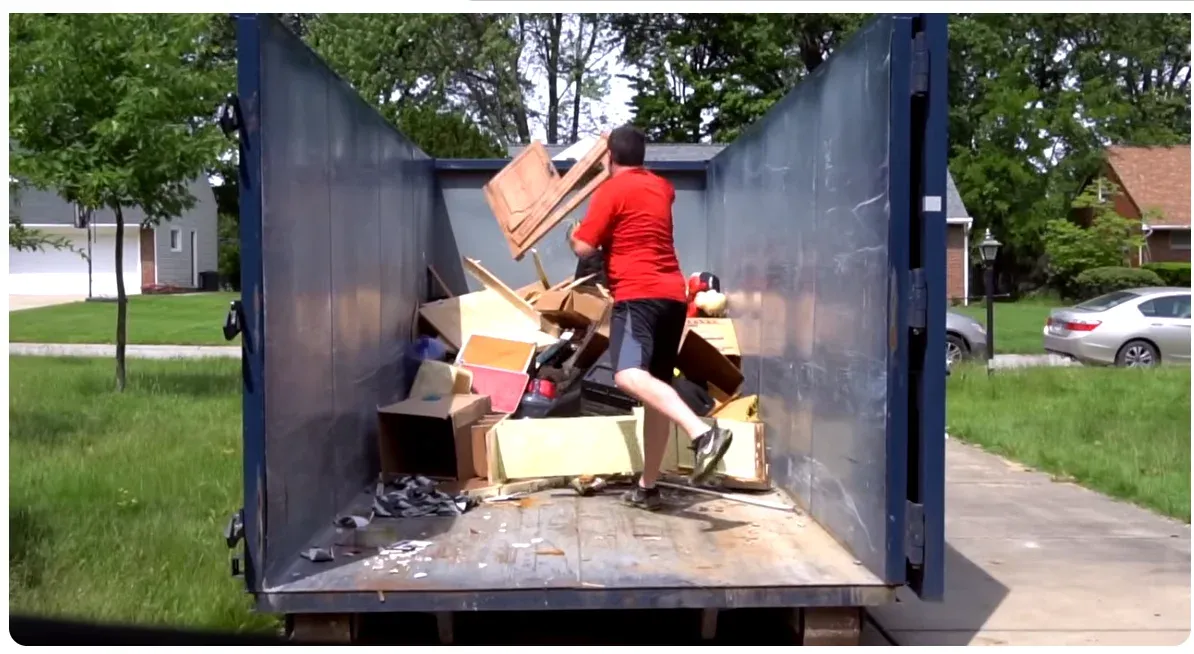 Homeowner loading a roll-off dumpster during a home cleanout in Asheville